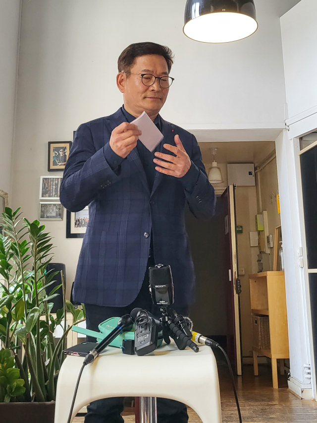 더불어민주당 송영길 전 대표가 22일(현지시간) 파리 3구 한 사무실에서 한국 특파원들과 만나 2021년 전당대회 돈 봉투 의혹과 관련해 입장을 밝히기 앞서 기자회견문을 꺼내고 있다. 연합뉴스