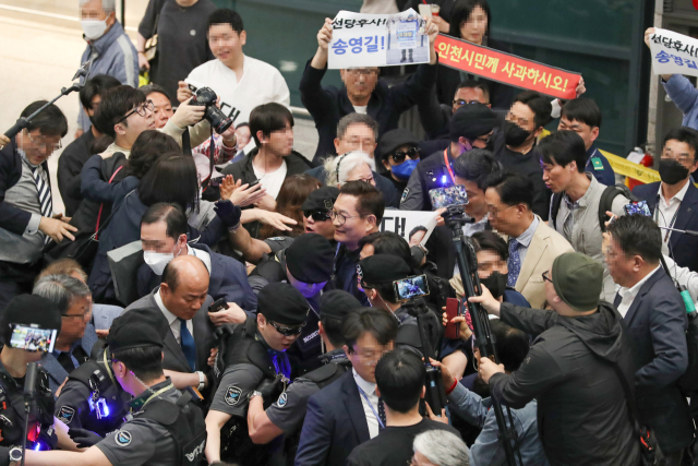 송영길 전 더불어민주당 대표가 24일 오후 인천국제공항 제1여객터미널을 통해 귀국해 송 전 대표 지지자와 규탄시민들에 둘러싸여 건물을 나가고 있다. 송 전 대표는 22일 프랑스 파리에서 2021년 전당대회 돈 봉투 의혹과 관련해 탈당 의사를 밝힌 뒤 조기 귀국했다. 연합뉴스