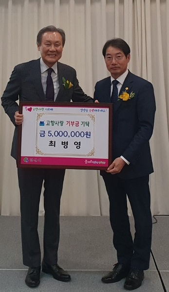 최병영(왼쪽) 재경경산시향우회장이 경산시 정규진 행정지원국장에게 고향사랑기부금 500만원을 전하고 있다.