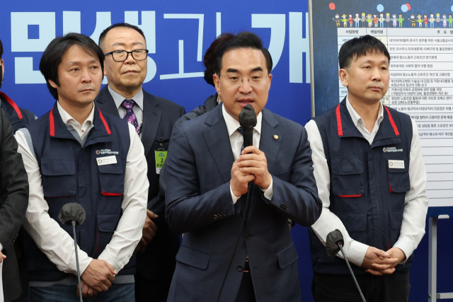 민주당 박홍근 원내대표가 25일 국회 당 사무실에서 을지로위원회 꽃달기 행사를 하고 있다. 이번 내용은 