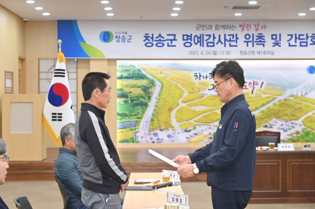 24일 청송군 명예감사관이 된 한 군민이 윤경희(오른쪽) 청송군수로부터 위촉장을 받는 모습. 청송군 제공