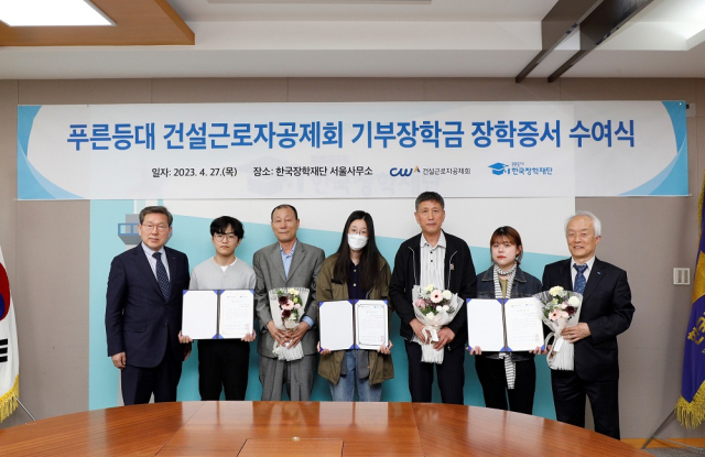 27일 한국장학재단 서울사무소 대회의실에서 배병일 한국장학재단 이사장(오른쪽 첫 번째)과 김상인 건설근로자공제회 이사장(왼쪽 첫 번째)이 장학증서 수여식에 참석하여 장학생 및 건설근로자들과 기념 촬영을 하고 있다. 한국장학재단 제공