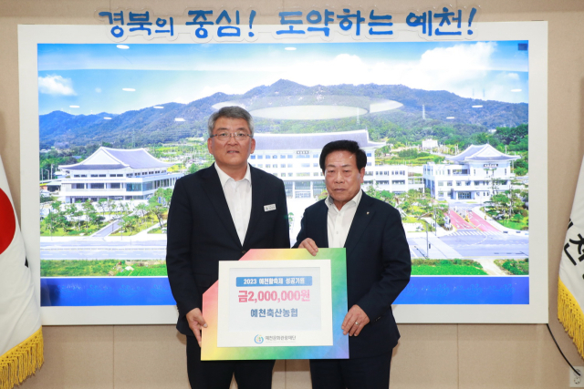 김민식 예천축협조합장(오른쪽)이 김학동 예천군수에게 예천활축제 성공을 위해 마련한 기부금 200만원을 전달하고 있다. 예천군 제공