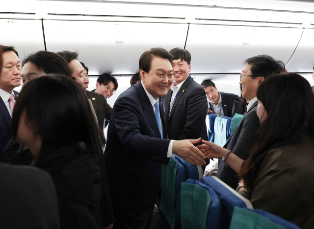 미국 국빈 방문 일정을 마친 윤석열 대통령이 29일(현지시간) 보스턴 로건 국제공항 출발에 앞서 공군 1호기 기내를 돌며 동행 기자들과 인사하고 있다. 대통령실 제공