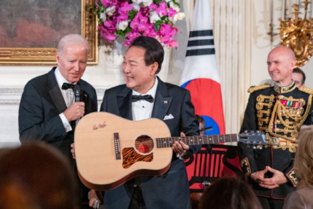 윤석열 대통령이 지난달 26일(현지시간) 미국 백악관에서 열린 국빈만찬 특별공연에서 조 바이든 대통령으로부터 미국 싱어송라이터 돈 매클린의 친필 서명이 담긴 기타를 선물받고 있다. 연합뉴스