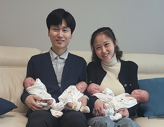 네쌍둥이를 품에 안은 송리원씨와 아내 차지혜씨. SK온 제공