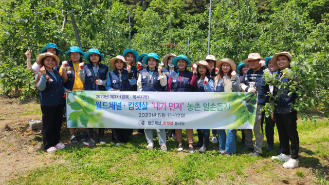 사과 적과 작업을 마친 이주여성들이 단체사진을 촬영하며 하트를 보내고 있다. 마경대 기자