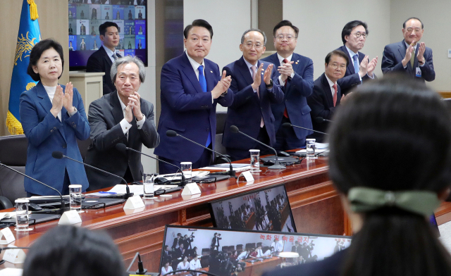 윤석열 대통령과 중대본 위원들이 11일 서울 용산 대통령실 청사에서 열린 코로나19 중앙재난안전대책본부 회의에서 코로나19 방역 최전선에서 활약한 의사, 간호사, 간호조무사 등 보건 의료진에게 격려의 박수를 보내고 있다. 연합뉴스