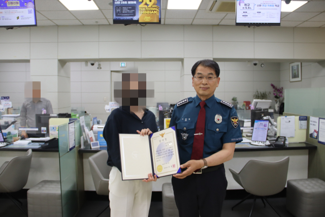 이동승 안동경찰서장이 지난 12일 보이스피싱 범죄를 예방한 신한은행 안동지점 A팀장에게 감사장을 전달하고 기념 촬영을 하고 있다. 안동서 제공
