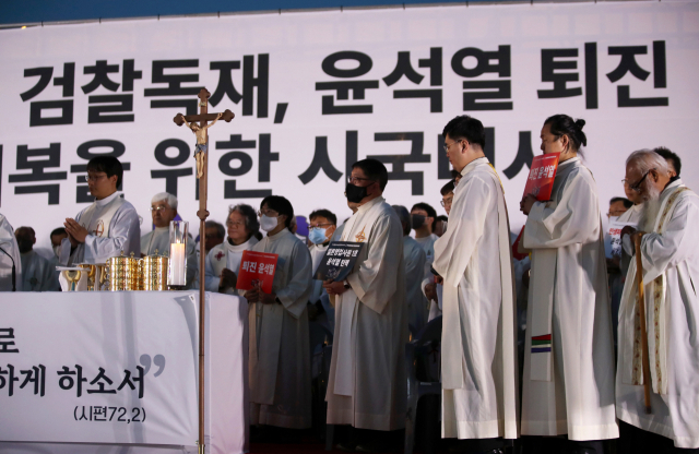 지난 1일 천주교정의구현전국사제단 소속 신부들이 오후 광주 동구 5·18민주광장에서 열린 친일매국 검찰독재 윤석열 퇴진과 주권회복을 위한 월요 시국 기도회에서 손팻말을 들고 있다. 연합뉴스
