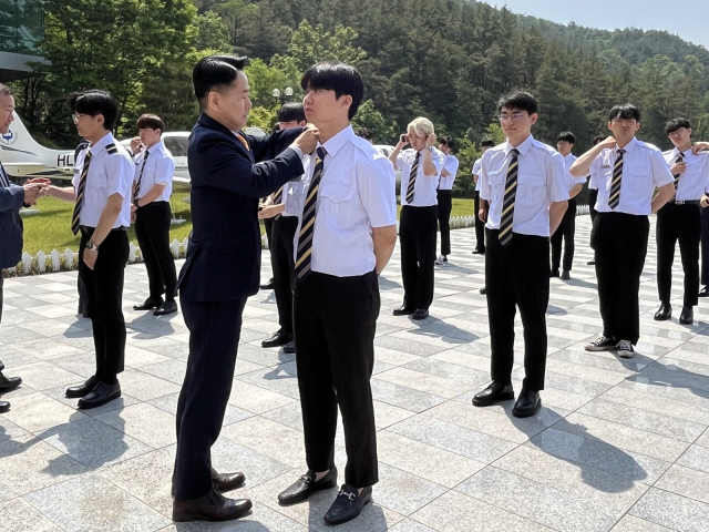 지난 15일 정진용 경운대 항공운항학과장이 학생들에게 견장을 달아주고 있다. 경운대 제공
