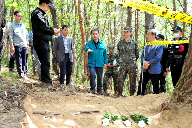 김진열 경북 군위군수, 재향군인회, 민주평화통일자문회의 관계자와 6·25 전사자 유해발굴 현장을 방문, 군 관계자의 설명을 듣고 있다.