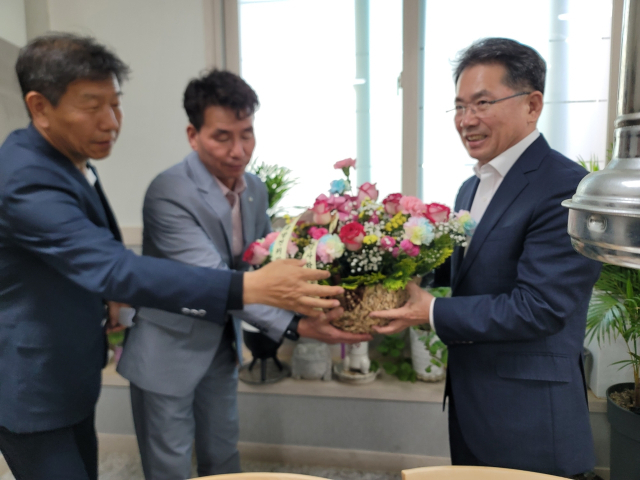 김진열 경북 군위군수가 군위인재양성원을 방문, 교사들에게 꽃바구니를 전달하고 있다. 군위군 제공