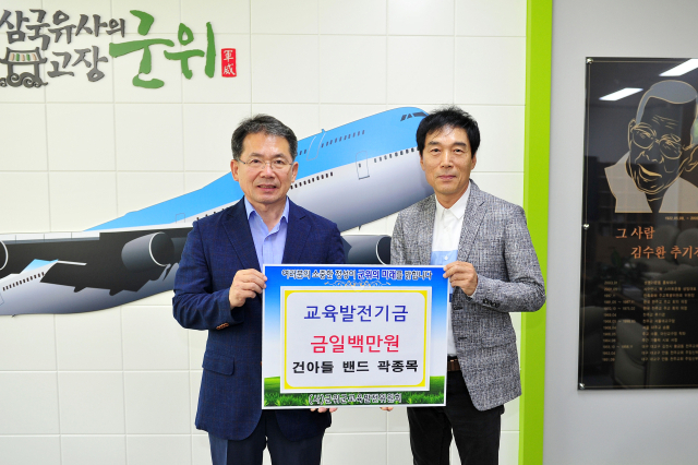 건아들 멤버인 곽종목(오른쪽) 씨가 고향 경북 군위군에 교육발전기금을 기탁하고, 김진열 군위군수와 기념 사진을 촬영하고 있다. 군위군 제공