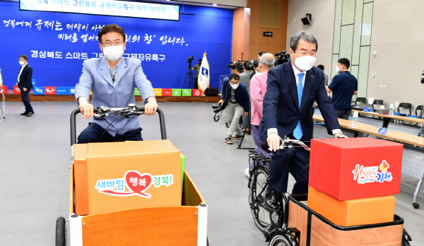 지난 2021년 스마트그린물류 자유특구 지정 브리핑에서 이철우 경상북도지사와 김충섭 김천시장이 카고바이크를 타고 있는 모습. 김천시 제공