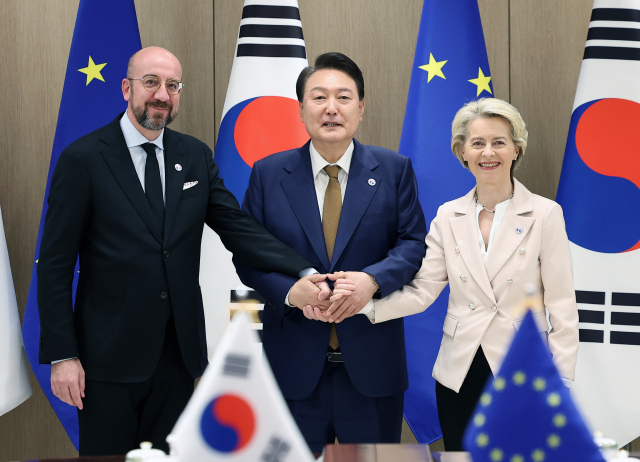 윤석열 대통령이 22일 서울 용산 대통령실 청사에서 열린 한-EU 정상회담에서 우르줄라 폰데어라이엔 EU 집행위원장, 샤를 미셸 EU 정상회의(이사회) 상임의장과 기념촬영을 하며 손을 잡고 있다. 연합뉴스