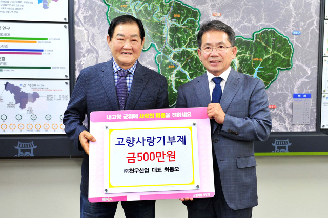 최동오(왼쪽) ㈜천우산업 대표가 군위군에 고향사랑기부금 500만원을 기탁하고, 김진열 군수와 기념 사진을 촬영하고 있다. 군위군 제공