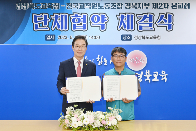 임종식 경북도교육감과 지승엽 전국교직원노동조합 경북지부장이 23일 본청에서 단체협약 체결식을 개최하고 협의서를 들고 기념 촬영을 하고 있다. 경북교육청 제공