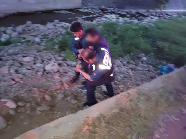 영주경찰서 직원들이 하천 바닥에 추락해 쓰러져 있던 실종자를 구조하고 있다. 영주서 제공
