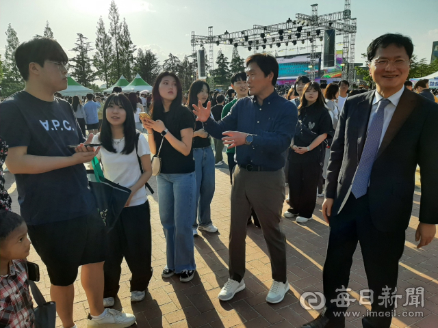 정창룡 매일신문 사장(오른쪽 앞)과 조현일 경산시장이 23일 영남대에 열린 2023 경산 대학인 청춘 공감 페스티벌에 참여한 한 대학생들과 이야기를 나누고 있다. 김진만 기자