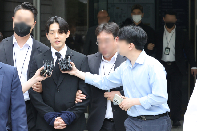 마약 투약 혐의를 받고 있는 배우 유아인과 유씨의 지인인 작가 A 씨가 24일 오후 서울중앙지방법원에서 영장실질심사를 마치고 호송차량으로 이동하고 있다. 연합뉴스