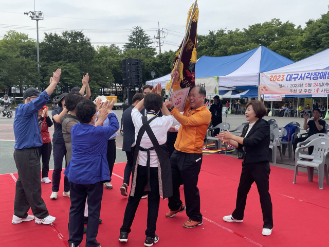 24일 대구시시각장애인연합회는 두류공원 인라인스케이트장에서 시각장애인 어르신들을 위한 체육대회를 진행했다. 이날 가장 높은 점수를 얻은 북구 지회가 우승 깃발을 흔들고 있다. 대구시시각장애인연합회 제공