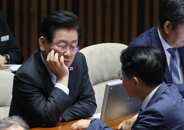 이재명 더불어민주당 대표가 25일 국회에서 열린 본회의에서 조정식 사무총장과 대화하고 있다. 연합뉴스