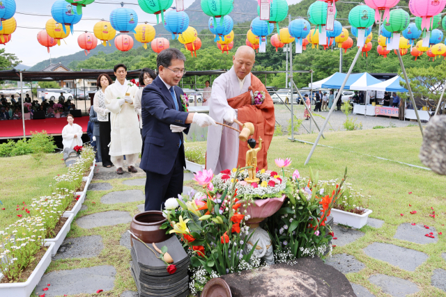 김진열 경북 군위군수가 인각사에서 열린 봉축법요식에 참석, 아기 부처님의 몸을 물로 씻는 관불의식을 하고 있다. 군위군 제공