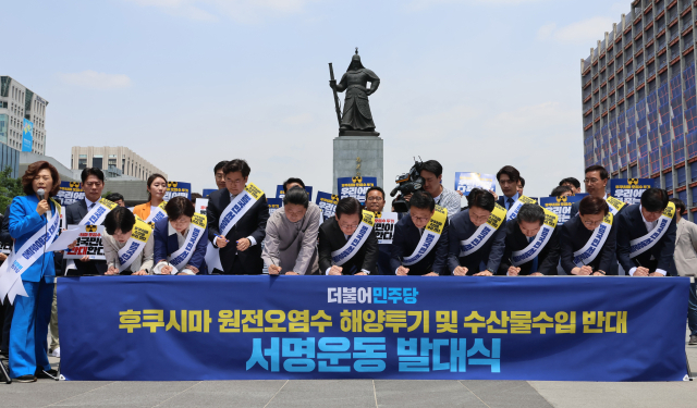더불어민주당 이재명 대표와 지도부가 26일 오전 서울 광화문광장 이순신장군 동상 앞에서 열린 후쿠시마 원전 오염수 해양투기 및 수산물 수입 반대 국민서명운동 발대식에서 서명하고 있다. 연합뉴스