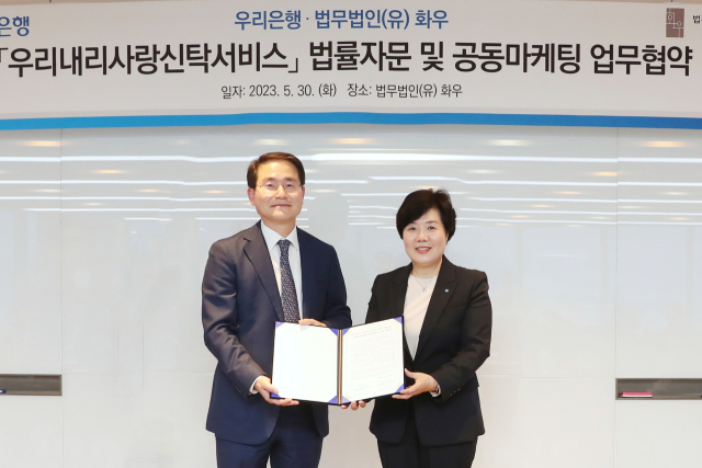 우리은행이 지난 30일 서울 강남구 소재 법무법인(유) 화우와 우리내리사랑 신탁서비스 공동마케팅 업무협약을 체결했다. 송현주 우리은행 투자상품전략그룹장(오른쪽)과 법무법인(유) 화우 이명수 대표 변호사가 기념촬영을 하고 있다. 우리은행