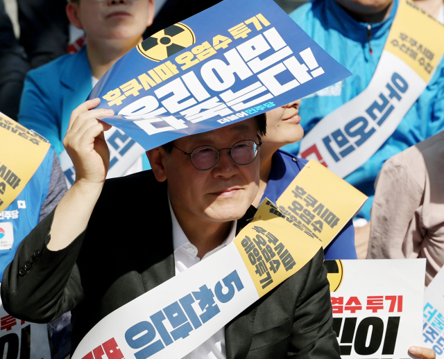 이재명 더불어민주당 대표가 3일 오후 부산 부산진구 서면에서 열린 후쿠시마 오염수 방류 반대 영남권 규탄대회에 참석해 손팻말로 햇빛을 가리고 있다. 연합뉴스