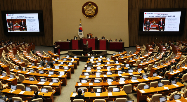 12일 국회 본회의에서 국민의힘 김석기 의원의 대정부 질문 때 민주당 이재명 대표와 주한중국대사의 회동 화면이 나오고 있다. 연합뉴스