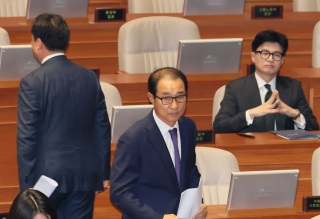 무소속 이성만 의원이 12일 오후 국회에서 열린 본회의에서 신상발언을 위해 한동훈 법무부 장관 옆을 지나 발언대로 향하고 있다. 뒷모습은 신상발언을 마친 윤관석 의원. 연합뉴스