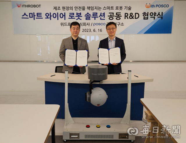 김도윤(오른쪽) 위드로봇 대표이사와 최용준 포스코 기술연구원 공정연구소 로봇솔루션연구그룹장이 스마트 와이어 로봇 개발 협력 체계 구축 업무협약 체결 뒤 스마트 와이어 로봇과 함께 기념촬영을 하고 있다. 포스코 제공