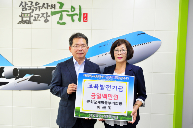 경북 군위군의 보화상 수상자 이금조(오른쪽) 씨가 군위군에 교육발전기금을 기탁하고, 김진열 군위군수와 기념 사진을 촬영하고 있다. 군위군 제공