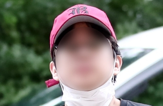 인천국제공항으로 향하던 여객기에서 비상문을 열려고 한 혐의를 받는 10대 남성이 20일 오후 구속 전 피의자 심문(영장실질심사)을 받기 위해 인천지법으로 들어서고 있다. 이 남성은 취재진을 향해 걸어오던 중 마스크를 턱 밑으로 내리며 얼굴을 공개했다. 연합뉴스