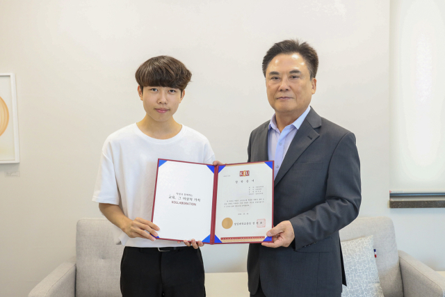 도로에서 위험에 처한 여자아이를 구한 선행을 인정받아 장학증서와 선행상을 받고 있는 최재호 씨. 경일대 제공