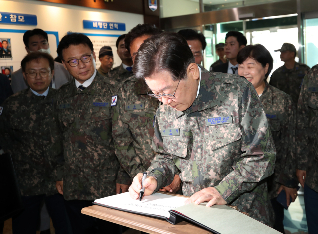 더불어민주당 이재명 대표가 23일 강릉산불 당시 진압 지원에 나섰던 공군 제18전투비행단을 방문, 서명록에 글을 남기고 있다. 연합뉴스