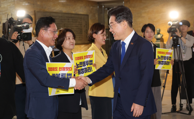 더불어민주당 이재명 대표가 19일 서울 여의도 국회 로텐더홀에서 노란봉투법 처리 촉구 피케팅을 하고 있는 정의당 의원들과 인사하고 있다. 연합뉴스