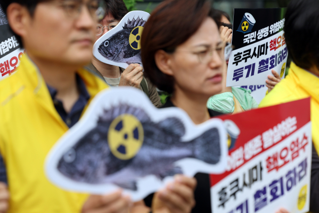 일본 후쿠시마 제1원자력발전소에서 나오는 오염수를 10ℓ 정도 마시는 것과 X-레이 사진 한 번 찍는 것의 방사능 노출 수준이 비슷하다는 주장이 국내에서 제기됐다. 26일 오전 서울 종로구 주한 일본대사관 앞에서 열린 일본 후쿠시마 원전 오염수 방류 저지를 위한 정의당 이정미 대표 단식 농성 돌입 기자회견에서 참가자들이 손팻말을 들고 있다. 연합뉴스