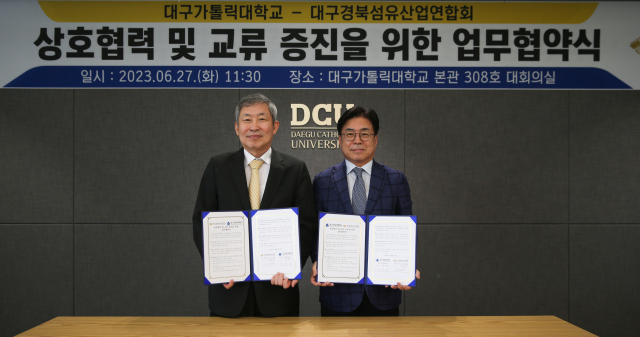 성한기 대구가톨릭대 총장(사진 오른쪽)과 조정문 대구경북섬유산업연합회장이 업무협약을 체결한 후 기념 촬영을 하고 있다.