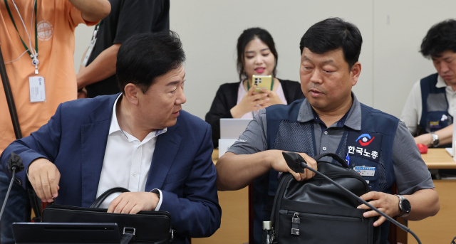 27일 오후 세종시 정부세종청사 최저임금위원회 회의실에서 열린 제8차 전원회의에서 사용자위원인 류기정 한국경영자총협회 전무(왼쪽)와 근로자위원인 류기섭 한국노총 사무총장이 대화하고 있다. 연합뉴스