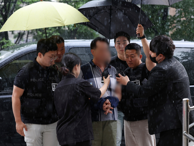 자신을 따돌린다는 이유로 직장에 불을 지르고 동료들을 다치게 한 혐의를 받는 이모씨가 29일 오전 서울 양천구 서울남부지법에서 열린 영장실질심사에 출석, 취재진의 질문에 답하고 있다. 경찰에 따르면 이씨는 지난 25일 영등포구자원순환센터 컨테이너에 불을 지른 혐의(현주건조물방화치상)를 받는다. 연합뉴스