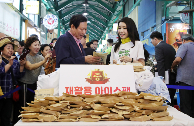 김건희 여사가 3일 오후 강원도 강릉시 중앙·성남시장을 방문해 재사용 아이스팩을 최영철 상인회장에게 전달하고 있다. 연합뉴스
