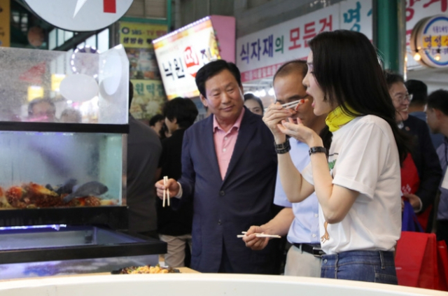 김건희 여사가 3일 오후 강원도 강릉시 중앙·성남시장을 방문해 횟집에서 오징어회를 시식하고 있다. 연합뉴스