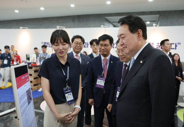 윤석열 대통령이 5일 서울 강남구 역삼동 한국과학기술회관에서 열린 제1회 세계 한인 과학기술인 대회 개회식에 참석한 뒤 미래 한인 과학인 곽세이 씨(프랑스)의 연구 관련 설명을 듣고 있다. 대통령실 제공