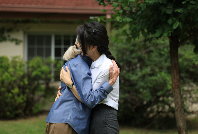 윤석열 대통령 부인 김건희 여사와 세계적인 영장류학자이자 환경운동가인 제인 구달 박사가 7일 서울 용산어린이정원 내 어린이 환경·생태 교육관 예정지에서 산사나무로 기념식수한 뒤 포옹하고 있다. 연합뉴스