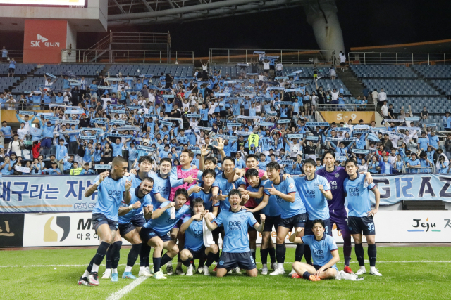 대구FC 선수들이 7일 제주에서 열린 K리그1 경기에 출격, 제주 유나이티드에 2대1로 역전승을 거둔 뒤 원정 응원 온 대구 팬들과 함께 기념 사진을 찍고 있다. 대구FC 제공