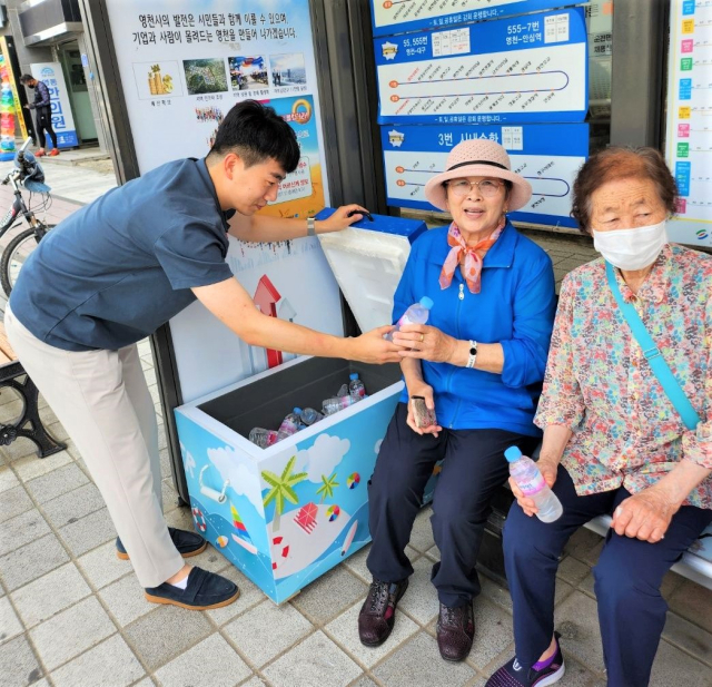 영천시 공무원이 공설시장 주변 버스 승강장에 비치된 아이스박스에서 생수를 꺼내 노인들에게 제공하고 있다. 영천시 제공