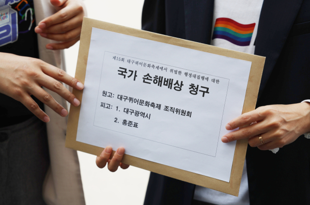 12일 오후 대구지법 앞에서 대구퀴어문화축제 조직위 관계자가 최근 대구 동성로에서 열린 퀴어축제 당시 행정대집행을 시도한 대구시와 홍준표 대구시장에 대한 국가손해배상 청구서를 돌고 있다. 조직위는 추가 법률 검토를 거쳐 13일 청구서를 법원에 낼 계획이다. 연합뉴스